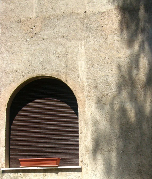 a bench near a window in a cement building