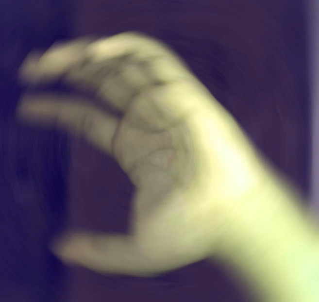 blurry pograph of hand in motion in front of window
