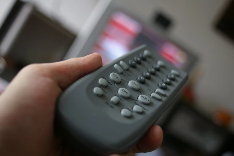 someone holding a remote control to use the television