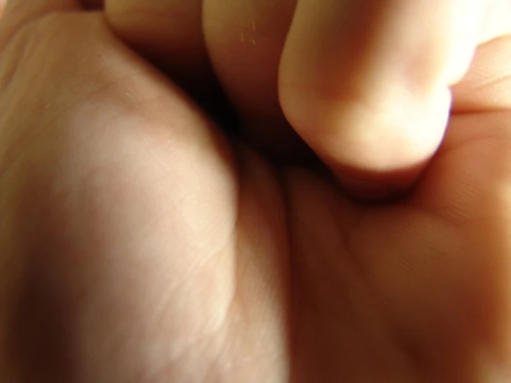 an upside down view of someones hand holding a cell phone