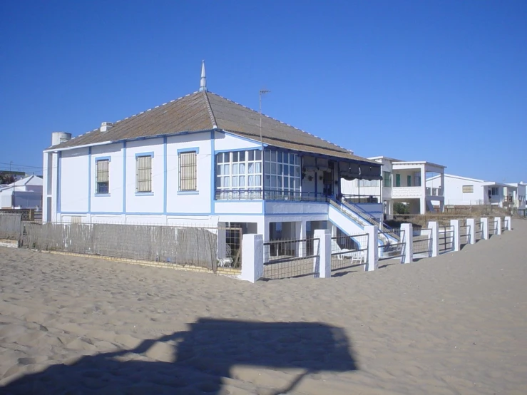 a large house on the beach near some houses