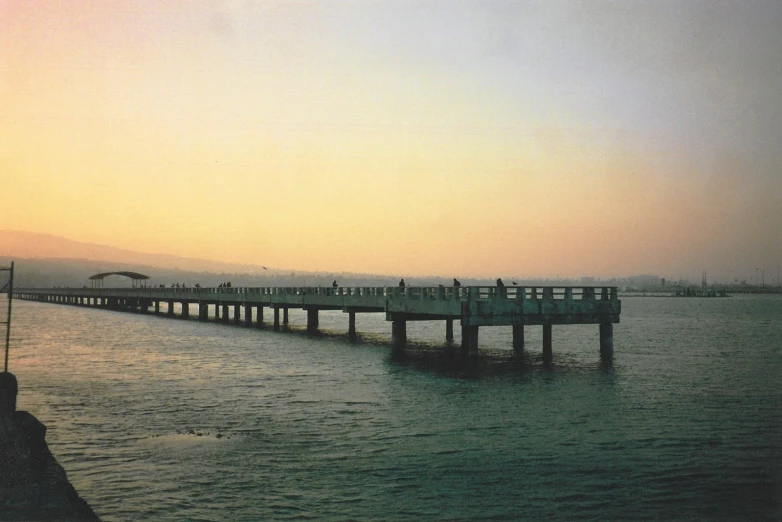 a pier in the ocean with people standing on it