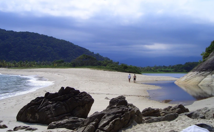 a couple walking towards the beach where they are staying