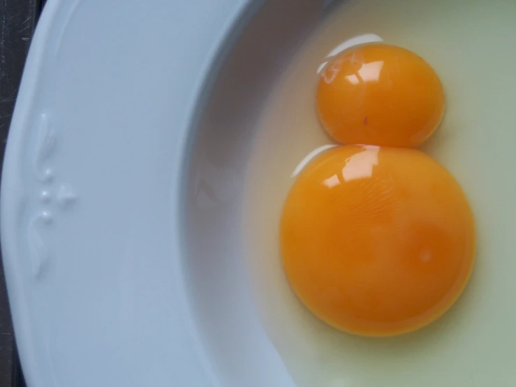 an egg sitting in a bowl with two other eggs