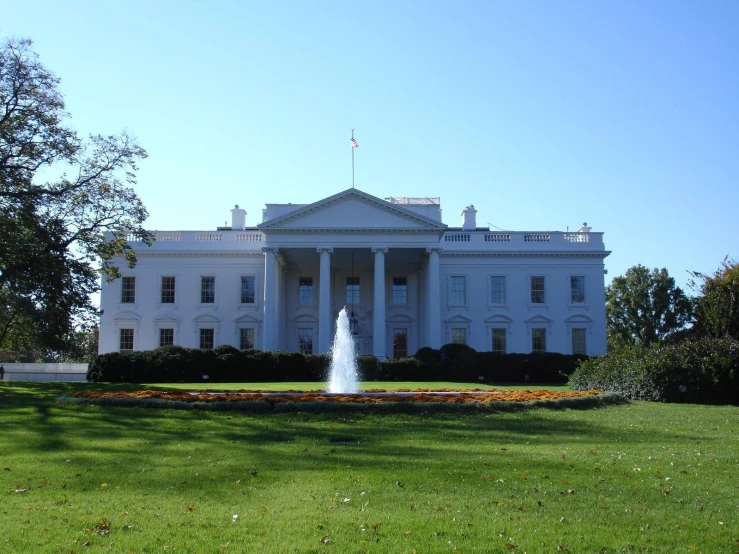 a huge white building with a water fountain in the center