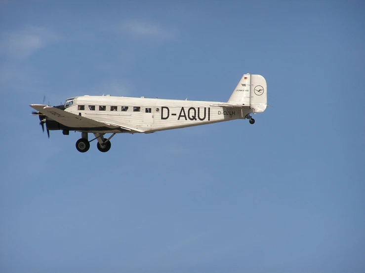 a small airplane flying in the air with a landing gear down