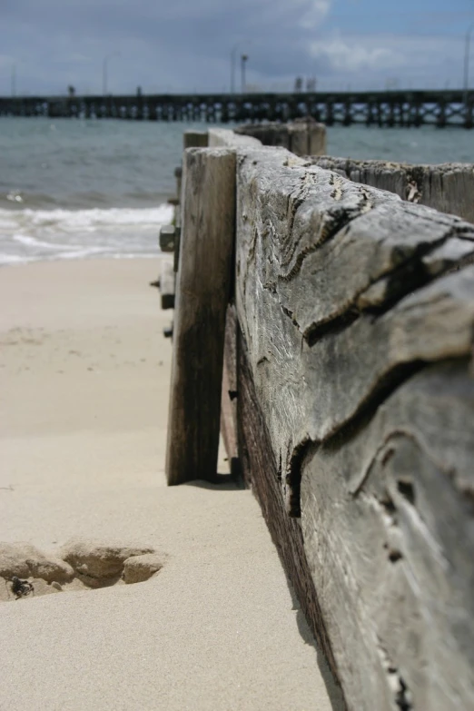 close up view of an old wooden rail on the beach