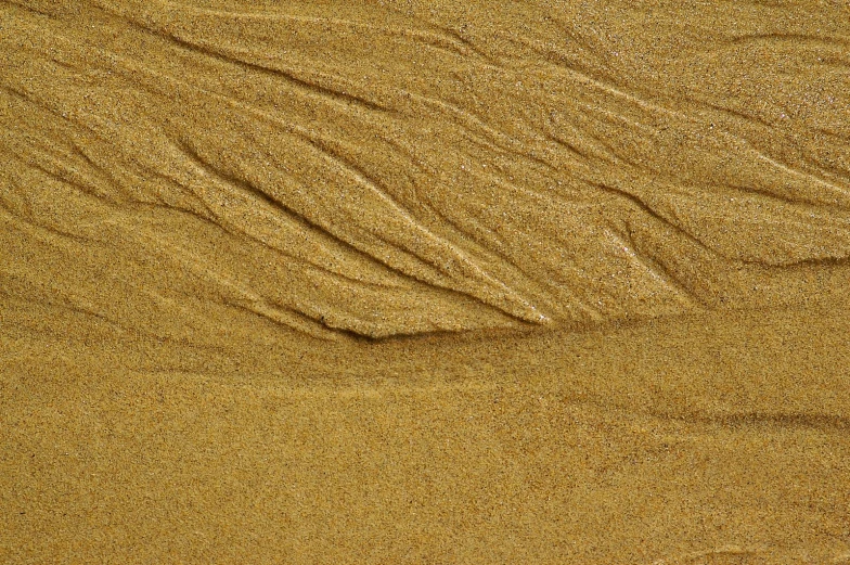 an image of the sand patterns made by water on the beach