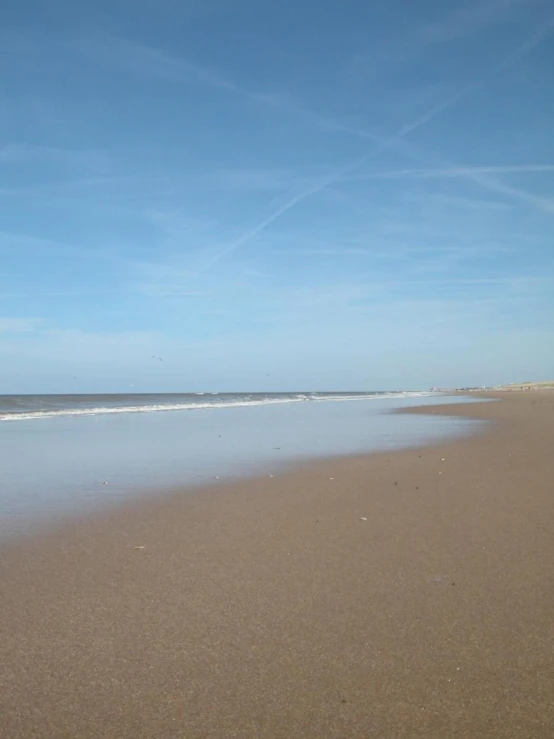 an ocean beach with two people on the water