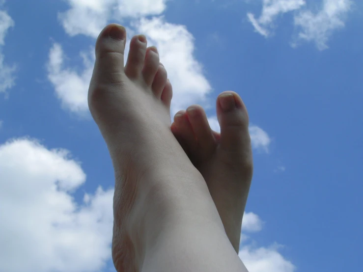 a bare foot and one toe in the sky