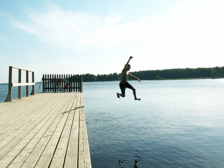 a person jumping into the water from a dock