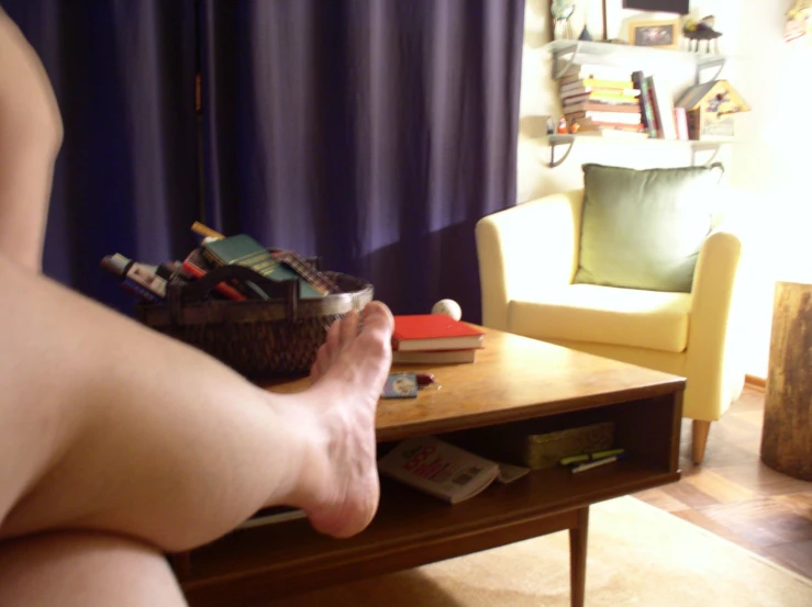 a person standing with their feet on a coffee table