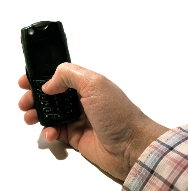 a close up of a person holding a black cell phone