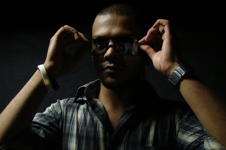 a man in black shirt and glasses wearing a watch