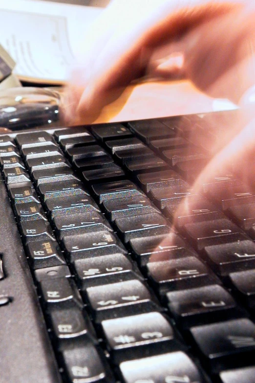 hands and fingers typing on a laptop keyboard