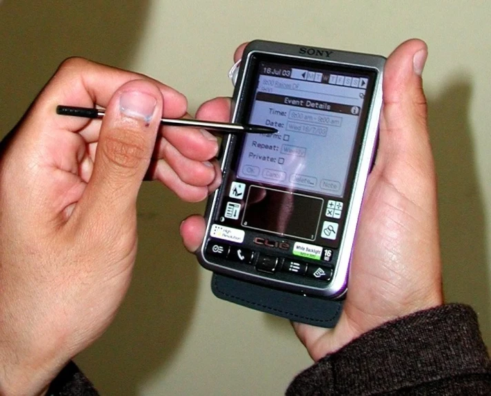 a person using a pen to write on a mobile phone
