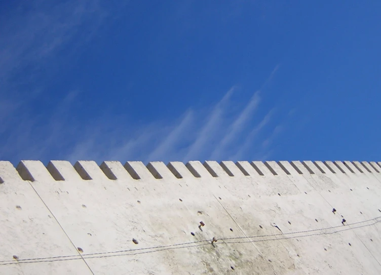 a cement wall with stone lined sides under a blue sky