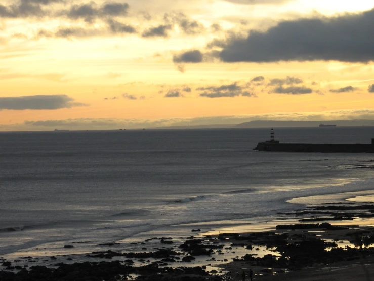 a large body of water with a lighthouse in the distance