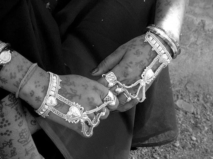 the hands are decorated with jewels and celets