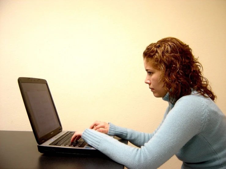 a woman that is sitting on her laptop