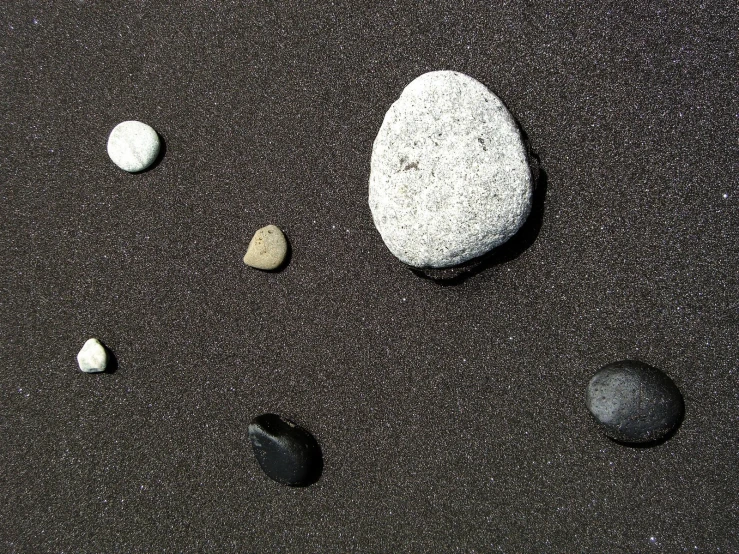 small rocks are sitting on the sand