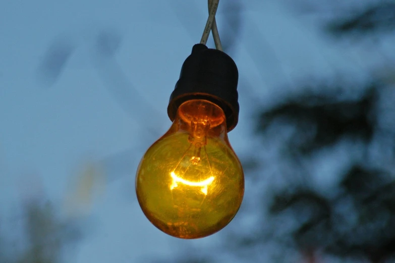 a light bulb hanging from a wire with a smile face