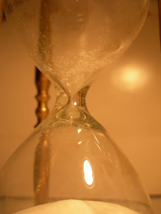 an image of a sand glass on top of white stone