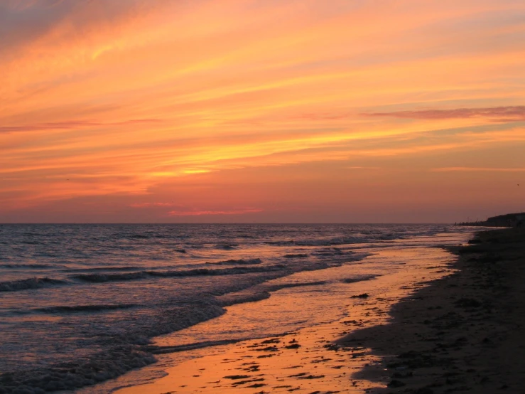 sunset view over a small body of water, with the sun setting behind the horizon