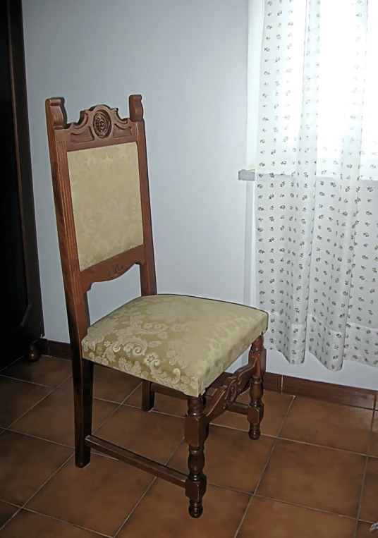 an old style chair with gold patterned back rest