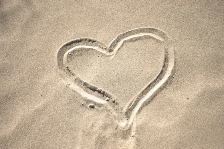 heart drawn in the sand of a beach