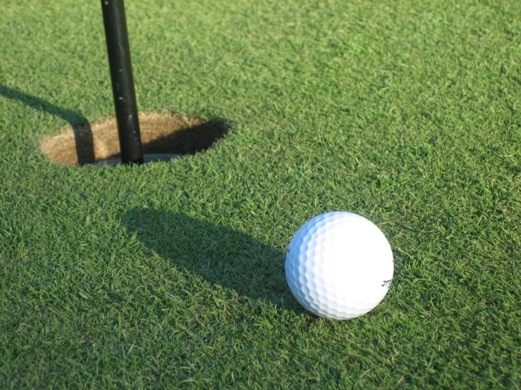 a golf ball is on the green near a hole