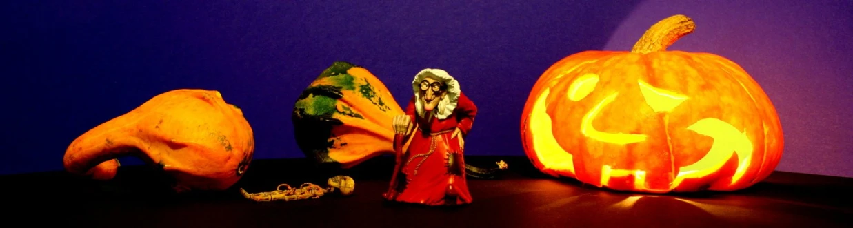 carved pumpkin with halloween theme and a figure beside