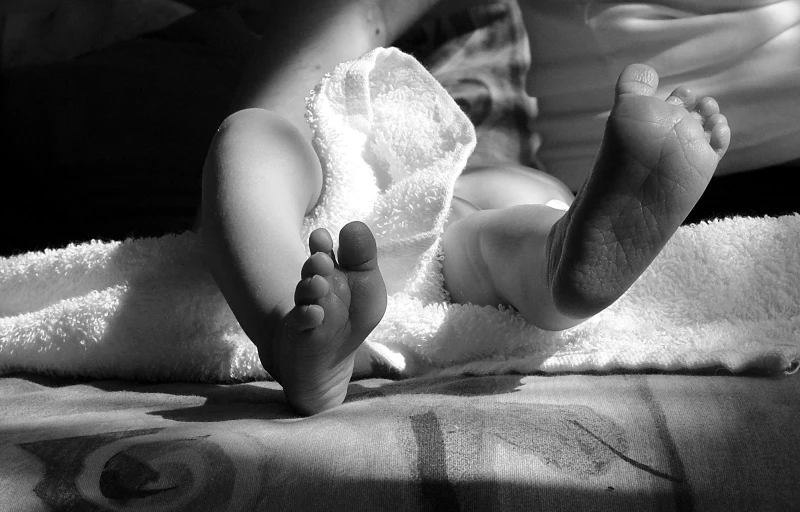 a black and white po of someone holding their feet in a towel