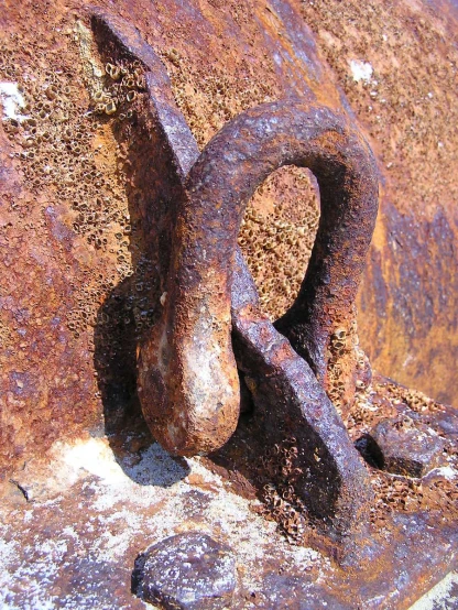 an old rusted padlock in front of a rusty wall