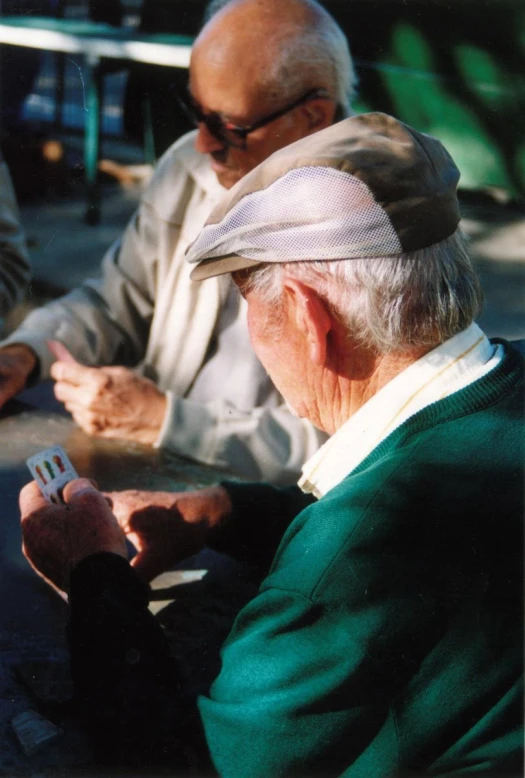 an older man and woman sitting together in the street