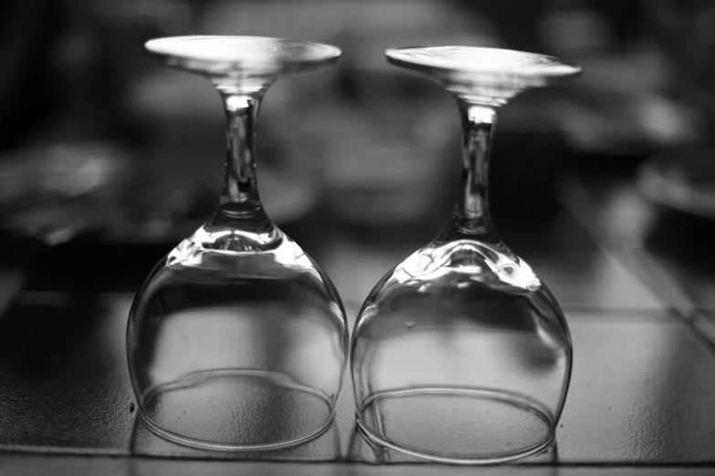 two wine glasses with a couple of them sitting on a table