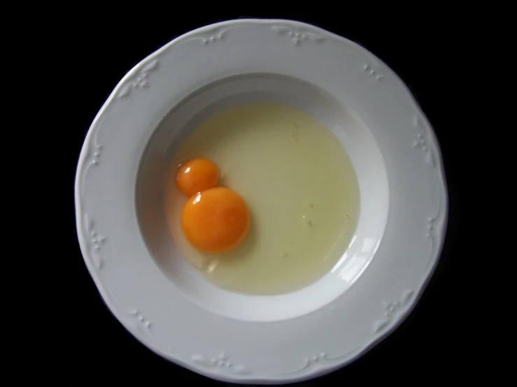 some eggs in a bowl on a black table