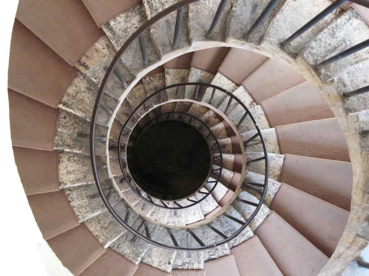 a view of a spiral stair with a stone wall and ceiling