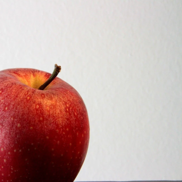 an apple sits on the table in front of a wall