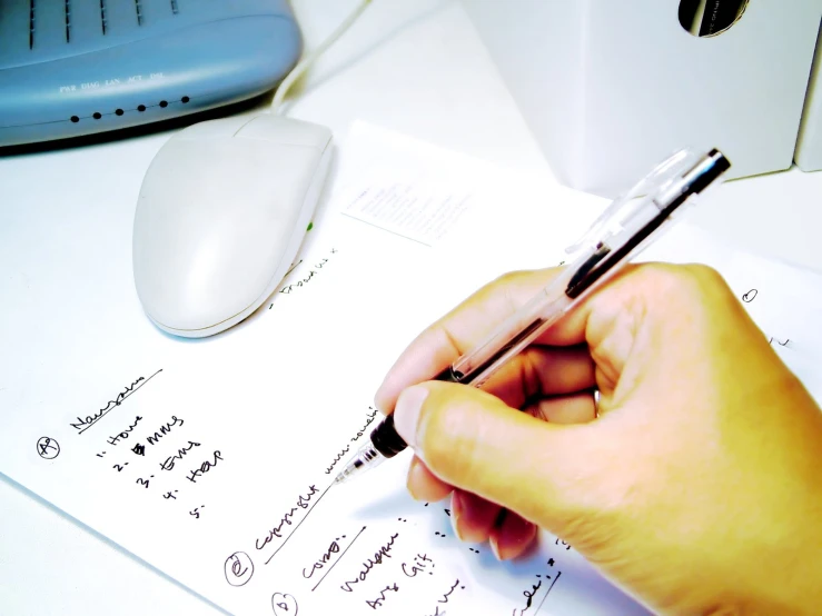 a person doing a work on a paper with a pen