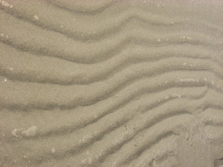 a beach area with white sand and a few ridges in it