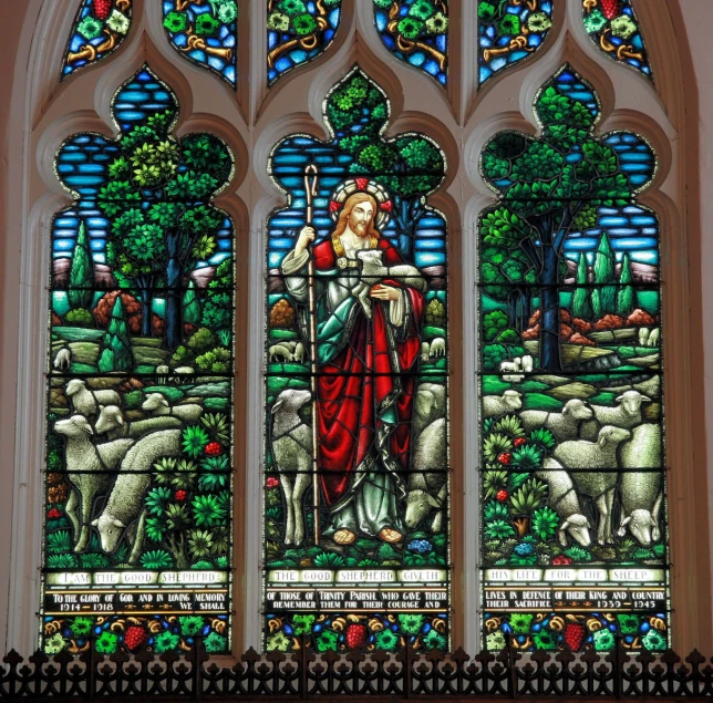 a stained glass window depicting the jesus with his sheep