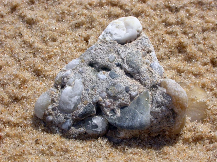 a rock is pictured laying in the sand