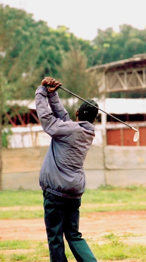 an older man hits the ball with his club