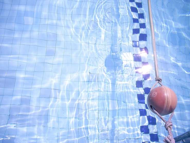 a swimming pool with an object that is on a rope