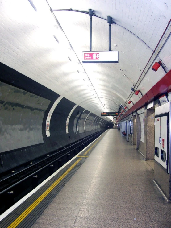 a subway platform with a long black and white train