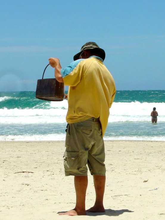 a man standing on the beach looking at waves