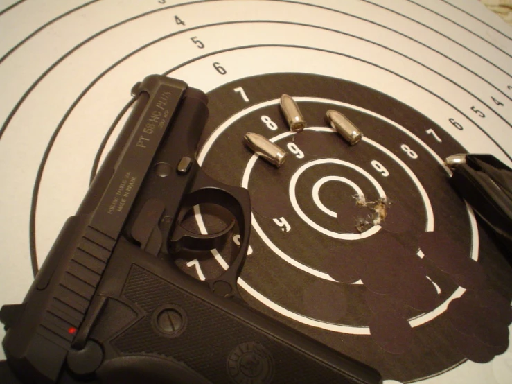 a gun with two rounds, and several bullet holes on it