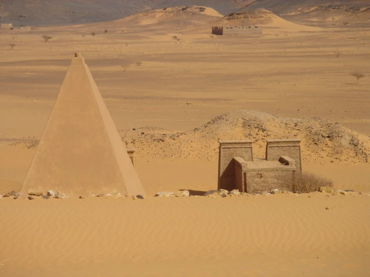 there are two sand structures standing in the middle of the desert