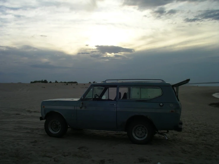 a car is parked in the middle of a beach